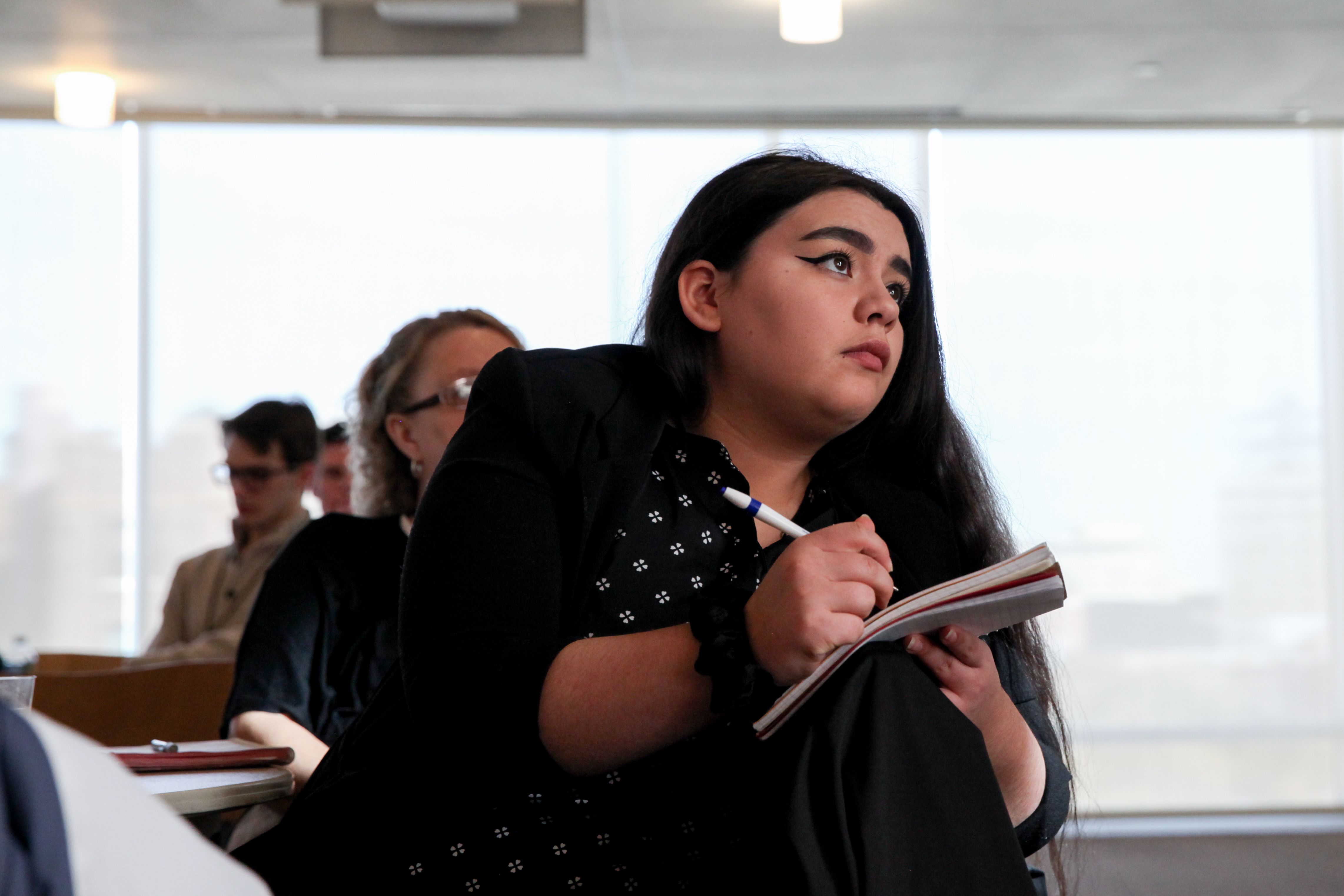 Students taking notes in a classroom.